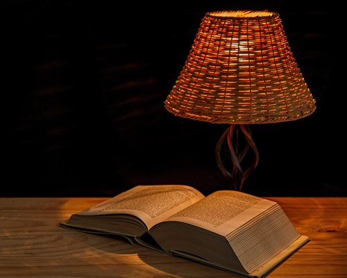 Open book under a warm directional reading lamp